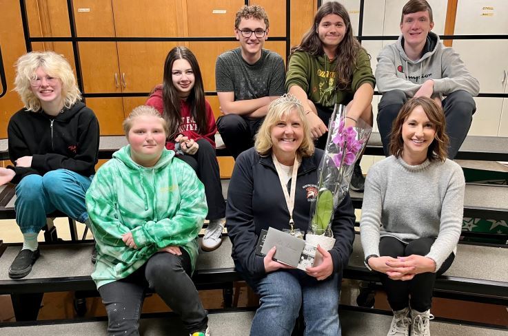 students and Leslie sitting on steps