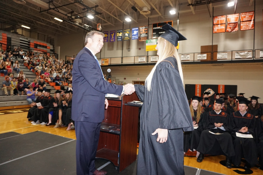 graduate shaking a man in a suit's hand