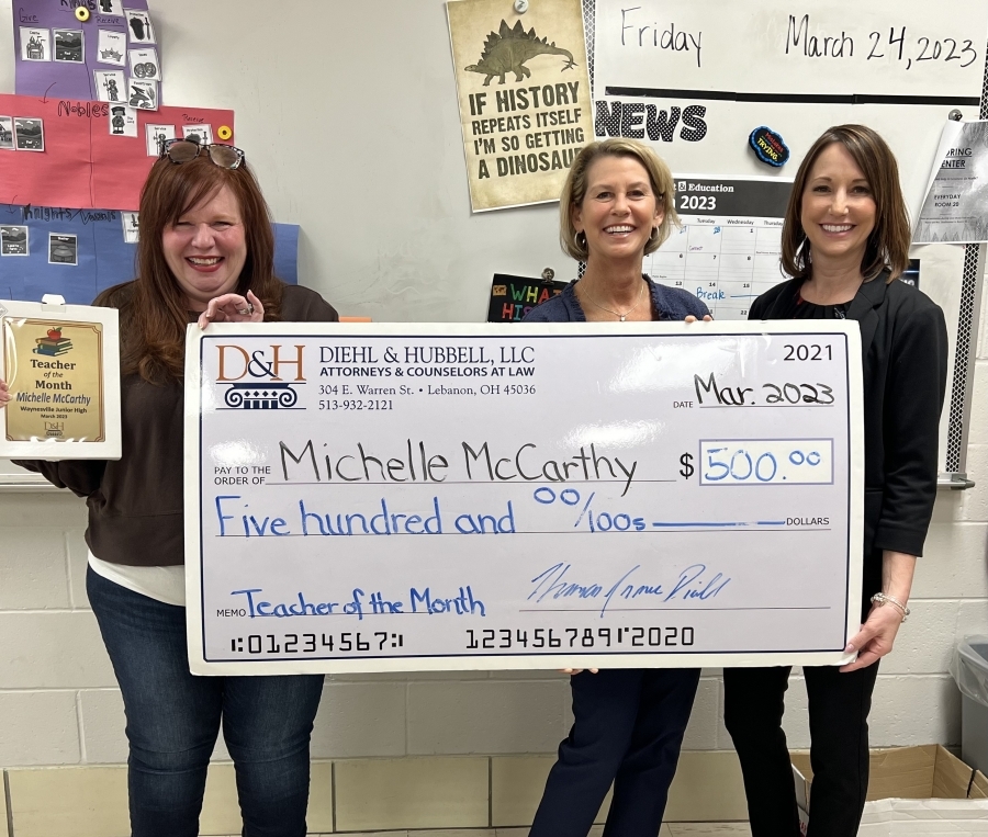three women with large check and one holding award