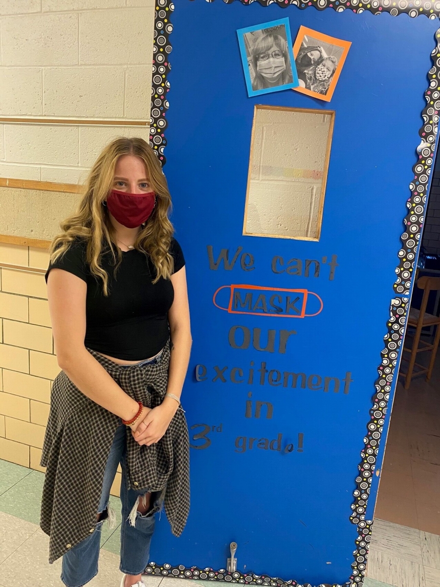 girl wearing a mask in front of a blue door