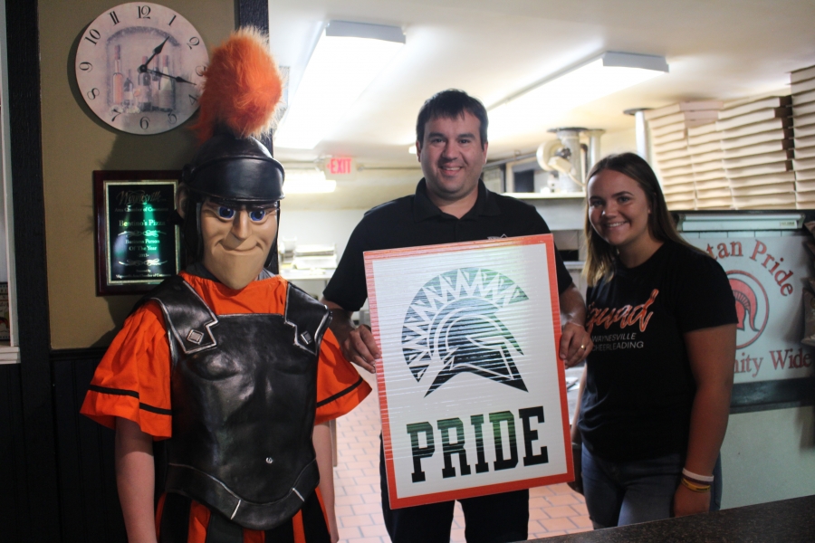 spartan mascot and three people holding a sign