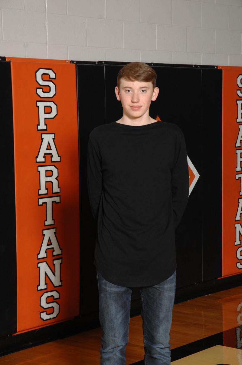 boy standing in front of orange and black cushioned walls
