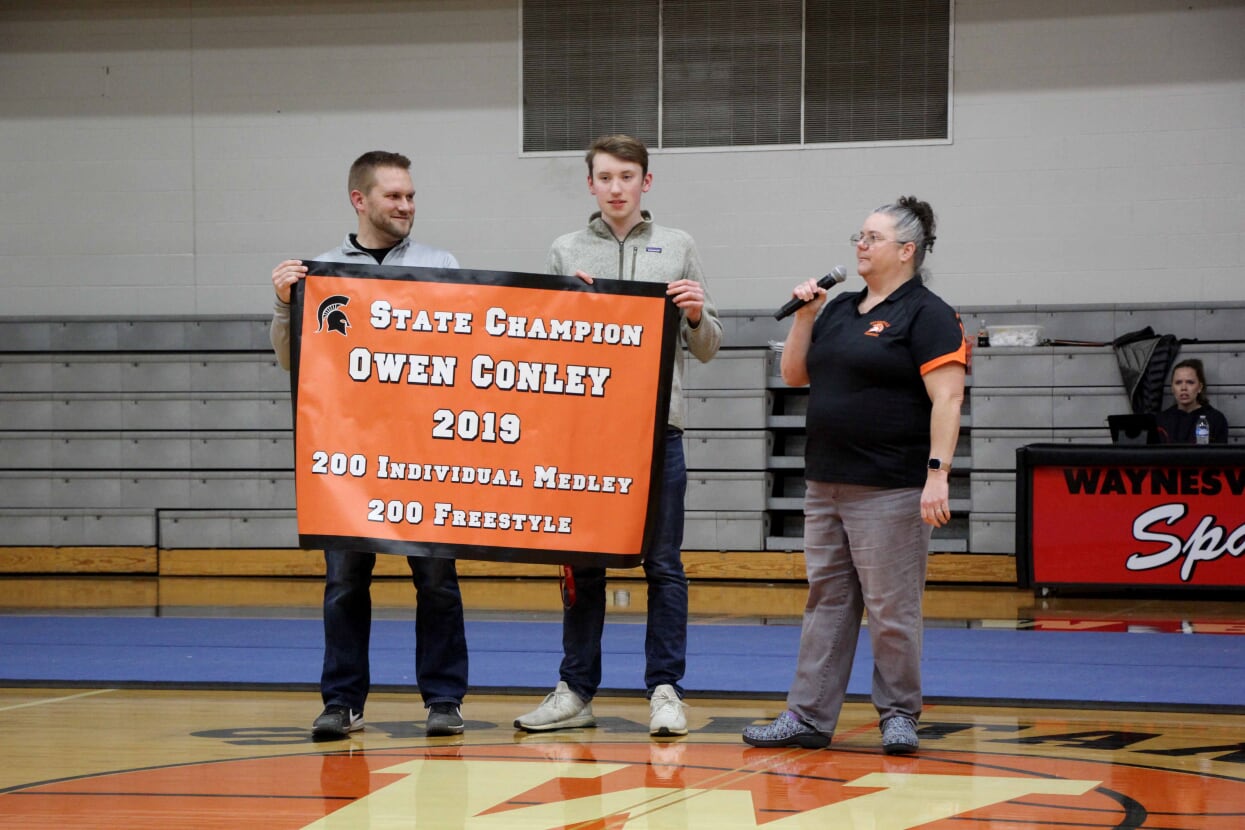 three people and a banner